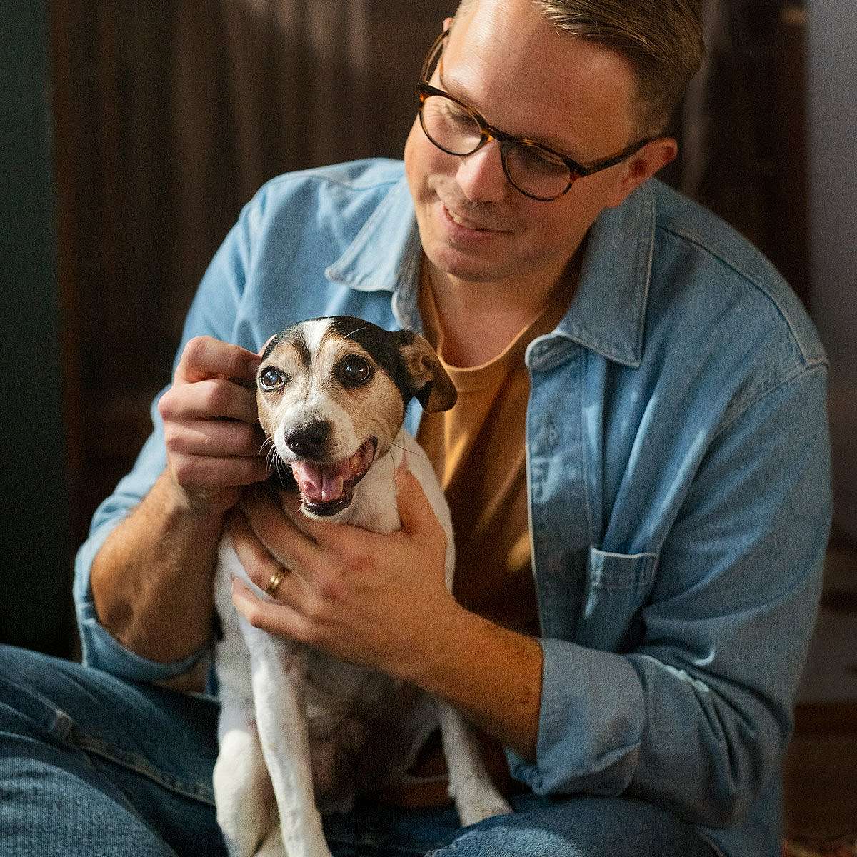 Man cuddles with dog